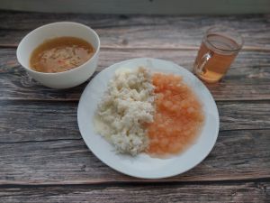 Zdjęcie przedstawia Dietę podstawową: Kapuśniak z kapusty kiszonej Ryż na sypko  Mus z jabłek prażonych  Sos budyniowy o smaku śmietankowym Kompot owocowy z jabłkami